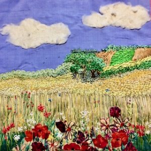 Textile panel showing golden field with poppies and blue sky with fluffy clouds