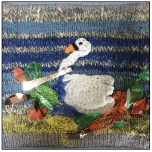 Knitted textile panel with swan nesting in rubbish