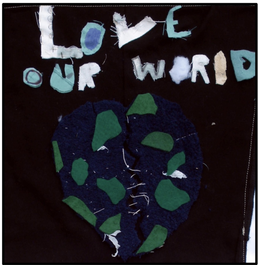A black background with textile art blue and green world with Love our World lettering